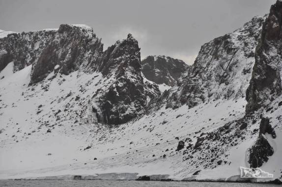 Paredes, escarpas e encostas que formavam o contorno da aniga caldeira vulcâncica que é hoje a baía de Deception Island, na Antártida